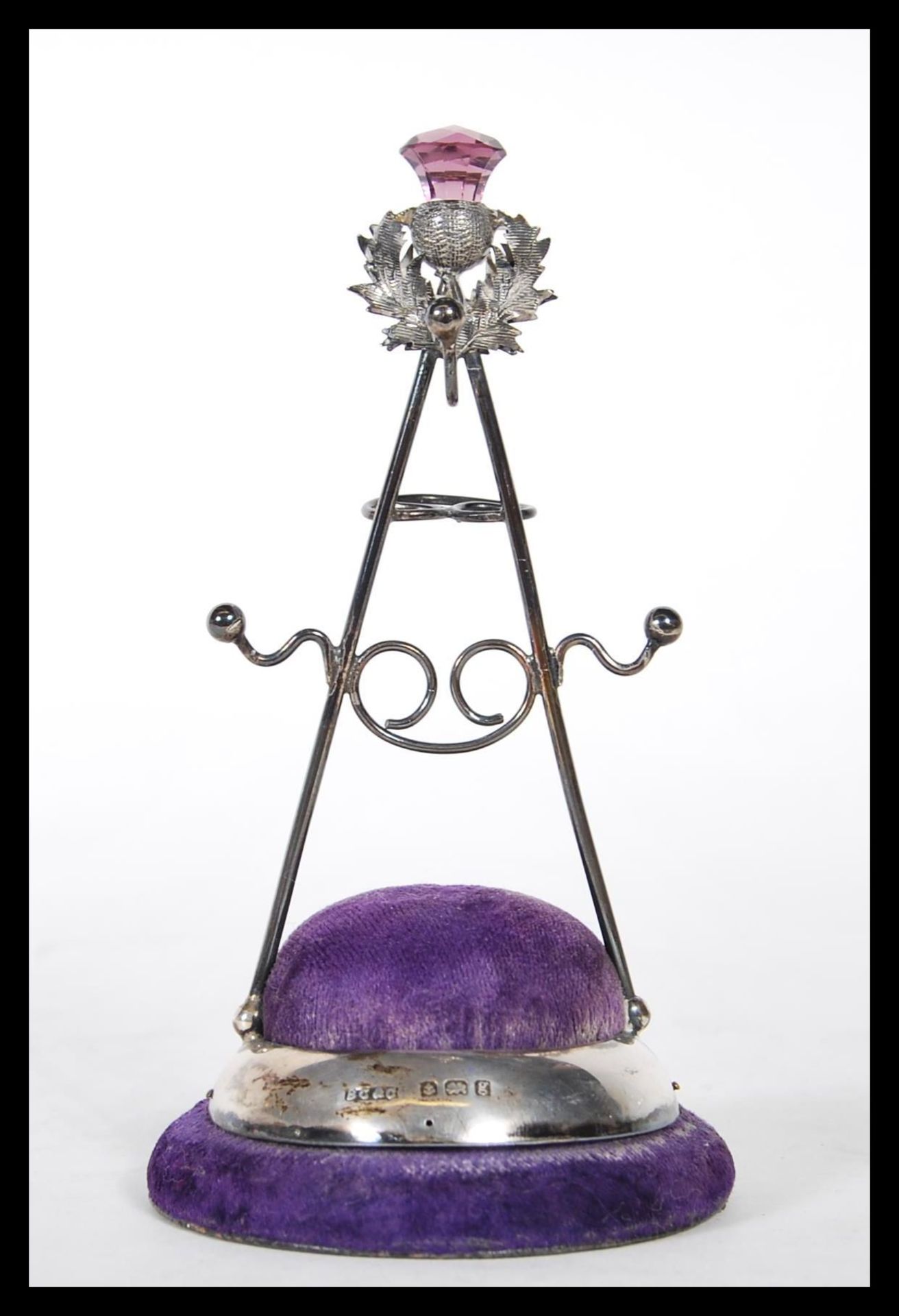 A silver hallmarked Britton, Gould & Co hat pin stand having a purple velvet cushion base with a