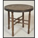 A 20th Century Indian brass topped Binares occasional table having engraved patterned decoration and