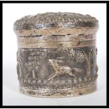 A 20th Century Anglo Indian silver white metal lidded jar decorated with hunting scenes in