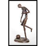 A 20th Century cast bronze figurine of a pre war footballer, the footballer in the action kicking