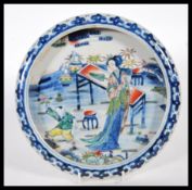 A early 20th Century dish / bowl having raised rim finished with blue decoration, the center of