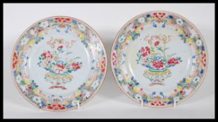 A matching pair of 18th Century Chinese plates having central basket of flowers with bow atop,