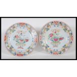 A matching pair of 18th Century Chinese plates having central basket of flowers with bow atop,