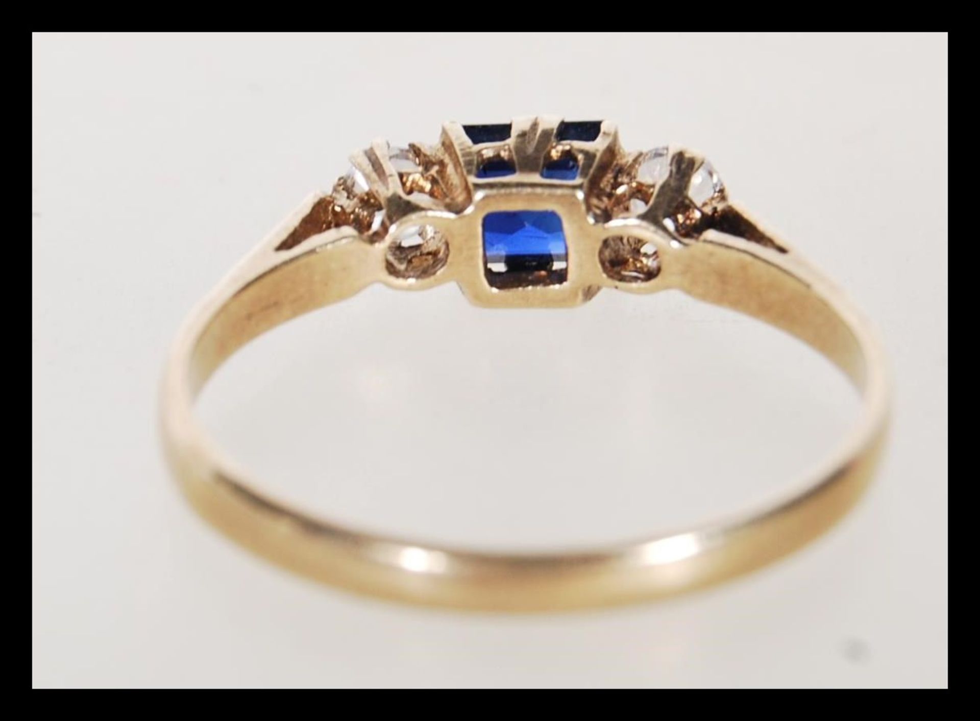 A hallmarked 9ct gold ladies ring set with a square cut blue stone flanked by two round cut white - Bild 3 aus 5