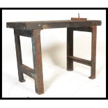 An early 20th Century industrial work bench, the bench constructed from a pair of cast iron