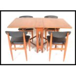 A retro 20th century teak wood drop leaf leg dining table together with a set of four matching