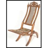 A 19th Century Victorian walnut folding campaign / nursing chair with carved and pierced top rail,