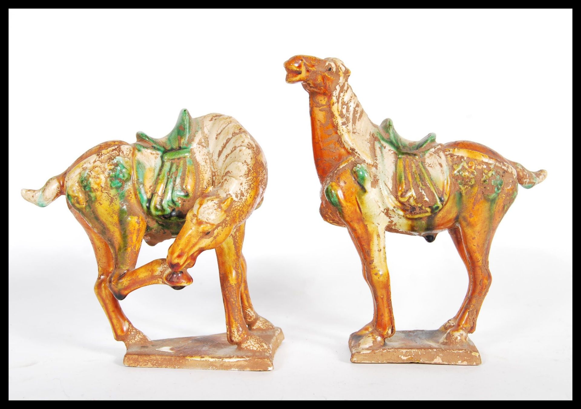 A pair of vintage 20th Century reproduction Chinese Tang dynasty ceramic War Horses. Having majolica