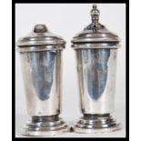 A pair of silver hallmarked salt and pepper table cruets of tapering form raised on stepped round