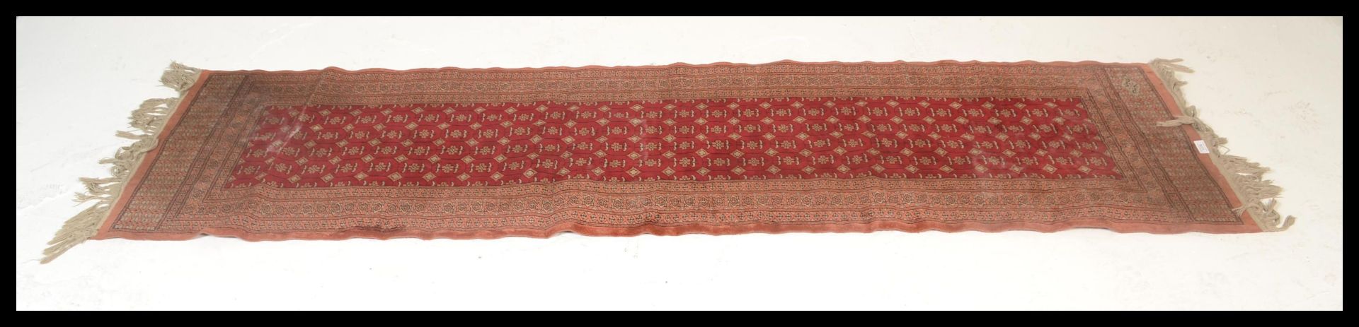 A vintage woolen Persian / Islamic floor rug runner set  on red ground,central panel with
