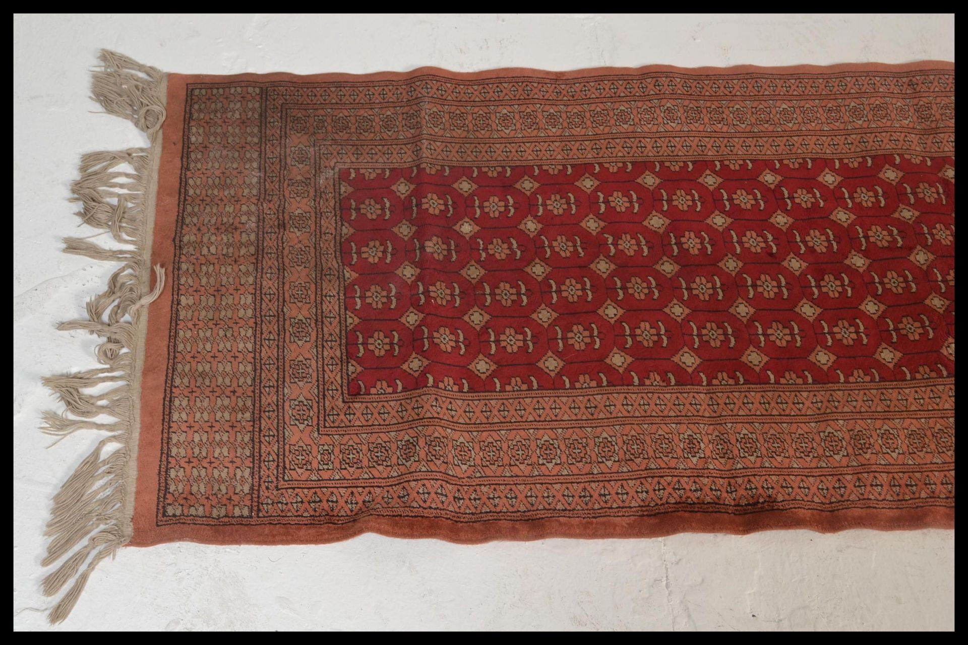 A vintage woolen Persian / Islamic floor rug runner set  on red ground,central panel with - Image 4 of 5