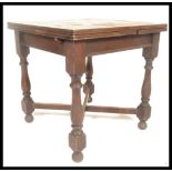 An early 20th century oak draw leaf dining table having,pull out leaves to each end being raised