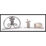 Two Dutch silver desk ornaments to include a letter rack having an articulated windmill and scrolled