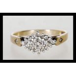 A hallmarked 9ct gold cluster ring set with white stones in a geometric cluster with accent stones