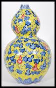 A 20th Century Chinese Juane ground double gourd vase, with blue decoration depicting bats around