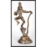 A cast brass Indian figurine of the Hindu God Lord Krishna dancing on the head of Kaliya, King of