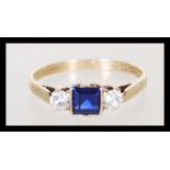 A hallmarked 9ct gold ladies ring set with a square cut blue stone flanked by two round cut white