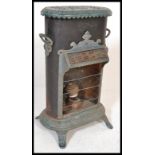 A 19th Century cast iron Petrolux stove heater, having stained glass canopy and enamel floral