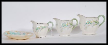 A collection of early 20th Century Art Deco Grindley Vine graduating jugs in the creampetal