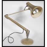 A vintage retro 20th Century industrial anglepoise desk or table lamp raised on circular base with