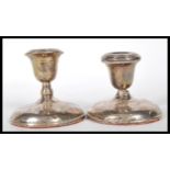 A pair of silver hallmarked filled stub candlestic
