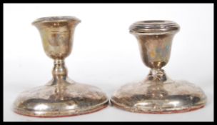 A pair of silver hallmarked filled stub candlestic