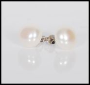 A pair of cultured pearl stud earrings on silver p