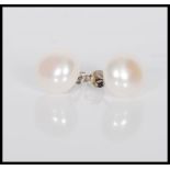 A pair of cultured pearl stud earrings on silver p