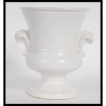 A vintage 20th century cream glazed pottery plant