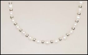 A row of cultured pearls having silver ball spacer