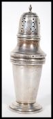 A silver hallmarked sugar shaker of tapering cylin
