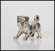A sterling silver figure of a dog have coloured ey