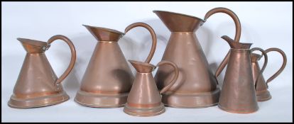 A collection of 6 19th century graduating copper cider measures. Each of shaped form having looped