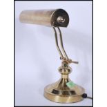 A vintage / retro 20th Century brass bankers desk lamp, having an adjustable brass shade raised on a