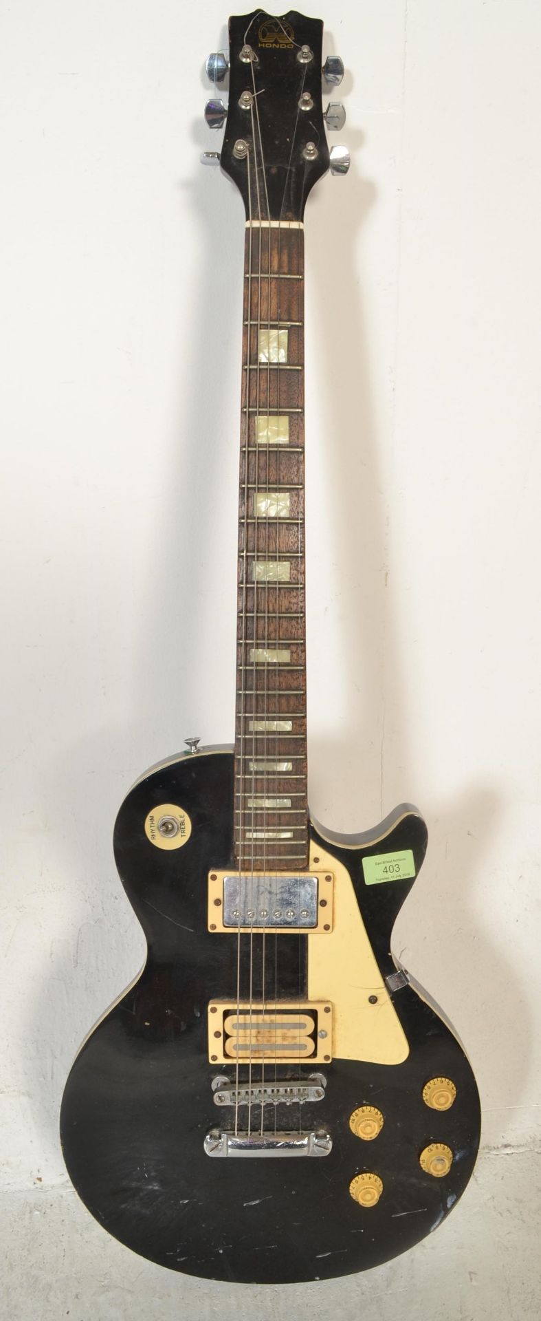 A vintage style  American made Hondo six string electric guitar, having a black body with white