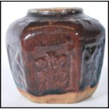 A Chinese monochrome hexagonal panelled ginger jar, moulded in relief with floral panels having a