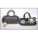 Two Radley handbags to include a black leather bag having purple and yellow sunburst decoration
