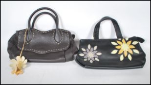 Two Radley handbags to include a black leather bag having purple and yellow sunburst decoration