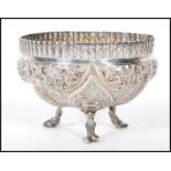 An Anglo Indian silver fret pierced dish raised on tripod feet, decorated in relief with fish and