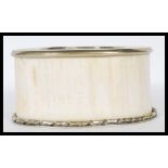 An early 20th Century ivory wine coaster / stand having a  white metal twist design base and top.