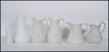 A collection of 20th century Portmeirion Parian ware jugs of graduating sizes, each cast in relief