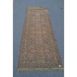 A large early 20th century handwoven Persian - Islamic runner rug having red ground with multiple