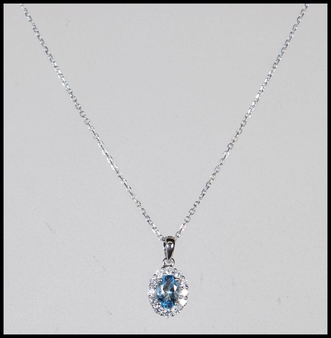 An 18ct white gold, aquamarine and diamond set necklace pendant set to a gold back chai. The central