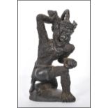 A 20th Century carved wooden figure in the form of Hauman the monkey God, being knelt on one knee