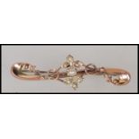 A hallmarked 9ct gold early 20th Century Edwardian bar brooch of scrolled form set with seven seed