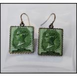 A pair of enamelled Victorian postage stamp earrings with Malta half penny stamps featuring Queen