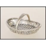A silver 20th century miniature ladies garden basket having weave construction and arched handles.
