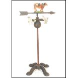 A vintage 20th Century cast iron painted weather vain being floor standing with quadruped weight