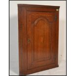 An 18th century George iII oak inlaid corner cabinet. The cabinet / cupboard with central door