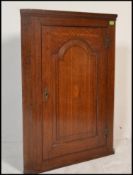 An 18th century George iII oak inlaid corner cabinet. The cabinet / cupboard with central door